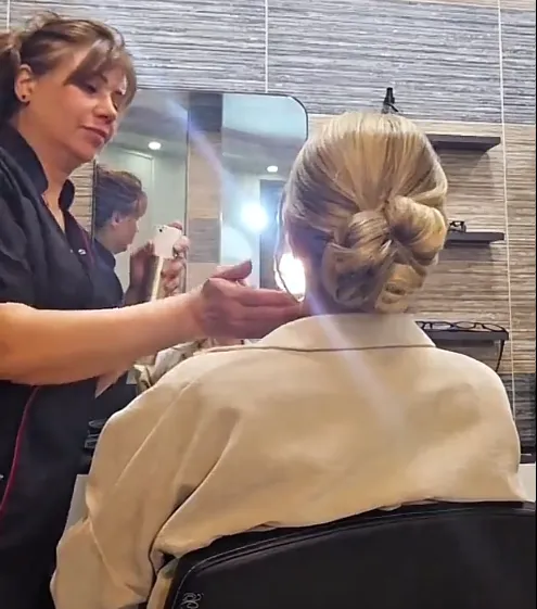 Lina die het haar van een klant stylet